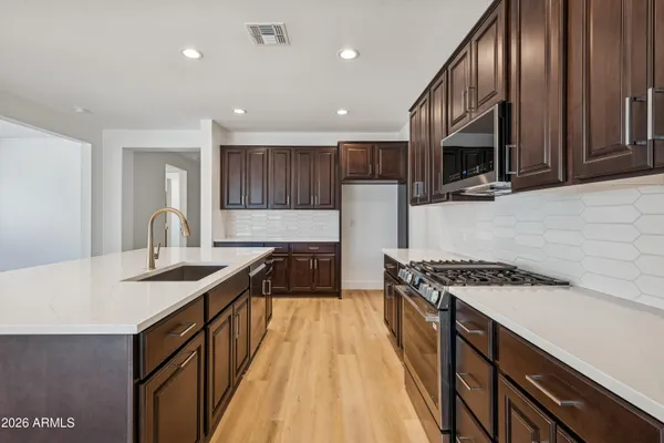 a kitchen with kitchen island granite countertop a sink a stove and a refrigerator