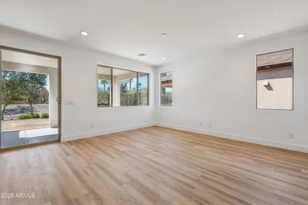 an empty room with wooden floor and windows