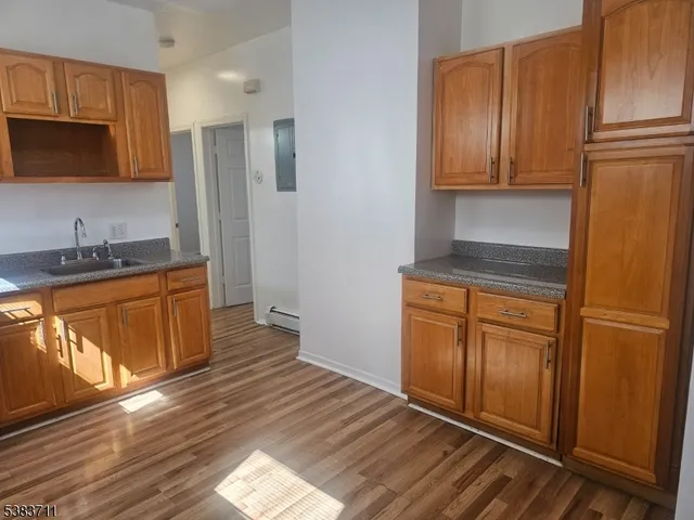 a kitchen with stainless steel appliances granite countertop a refrigerator a stove and a sink with wooden cabinets