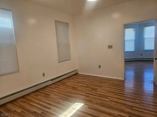 a view of empty room with wooden floor