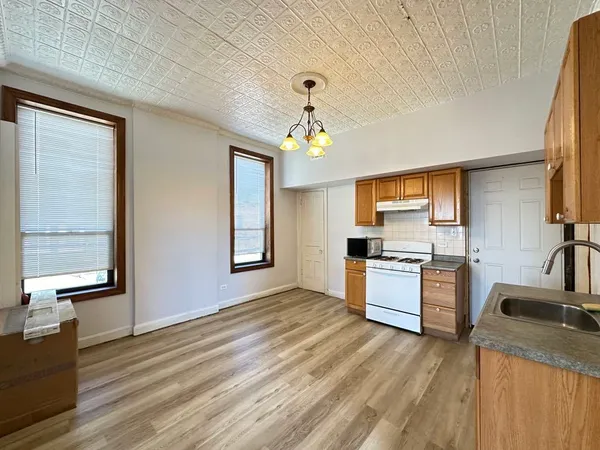 a kitchen with a refrigerator a stove top oven a sink dishwasher and wooden floor