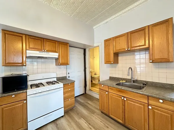 a kitchen with a sink stove top oven and cabinets