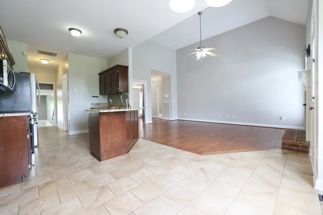 a view interior of a kitchen with stainless steel appliances granite countertop cabinets and chandelier
