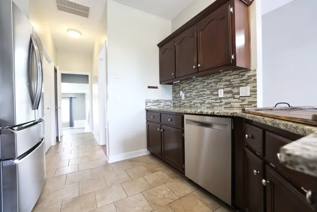 a kitchen with stainless steel appliances granite countertop a sink stove and cabinets