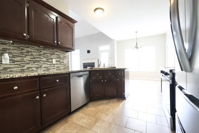 a kitchen with a sink a refrigerator and wooden cabinets