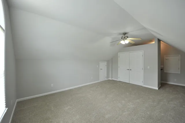 a view of an empty room with a chandelier fan