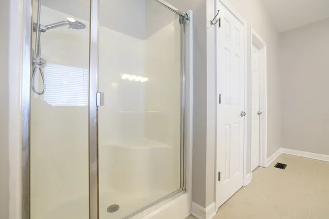 a bathroom with a glass shower door and a glass door
