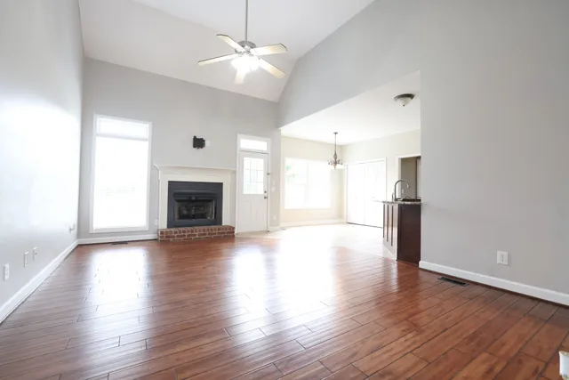 a view of a livingroom with wooden floor a fireplace and window