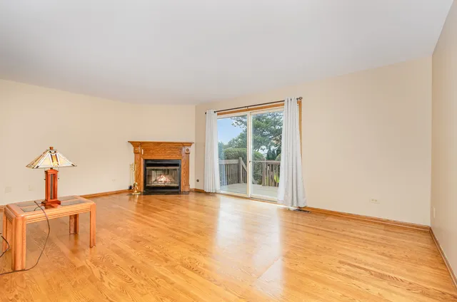 a view of empty room with wooden floor and fireplace
