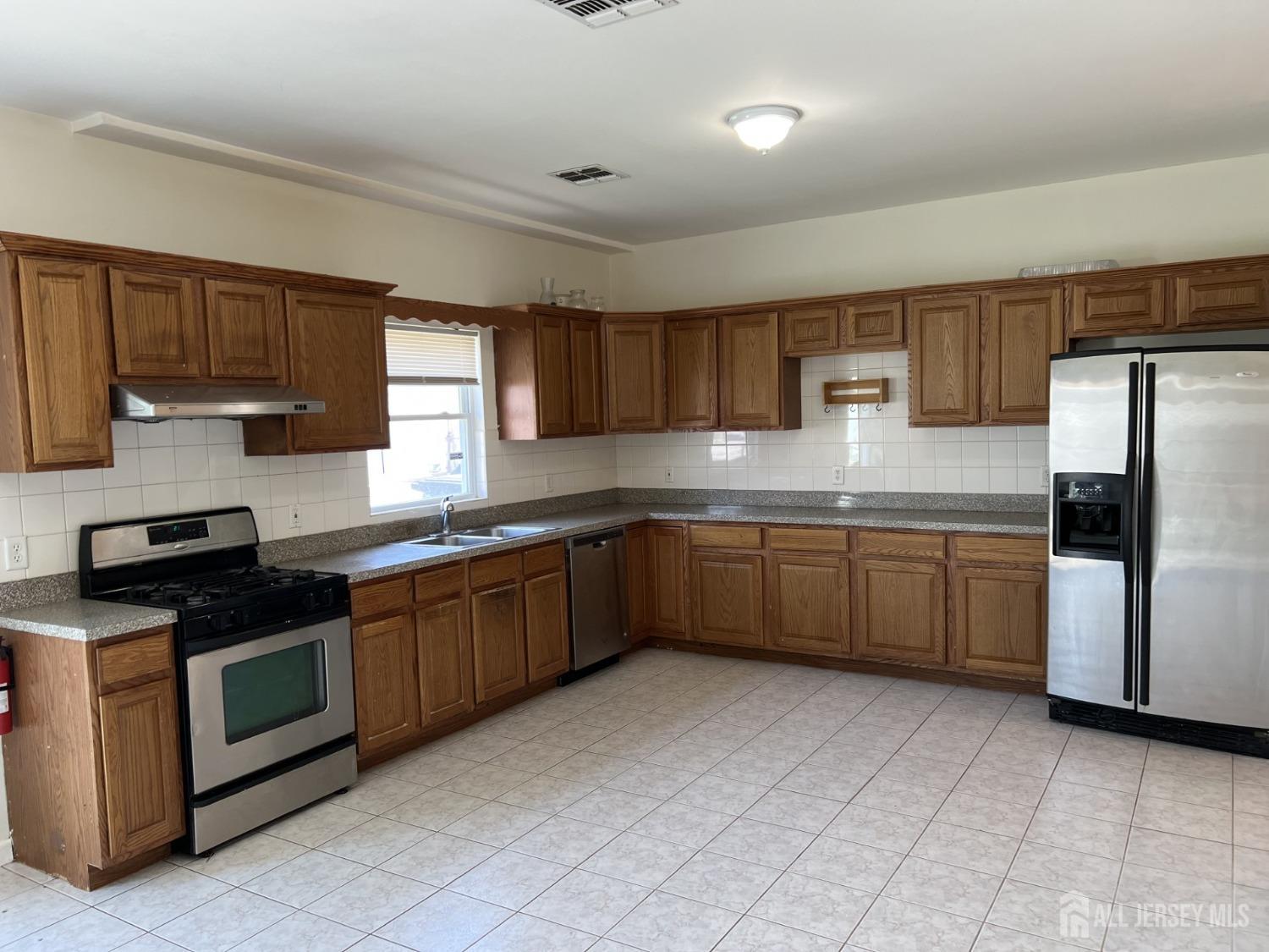 22 North Whittier Street, Unit B Carteret, NJ 07008 - Photo 13 of 27 a kitchen with a sink cabinets stainless steel appliances and a window