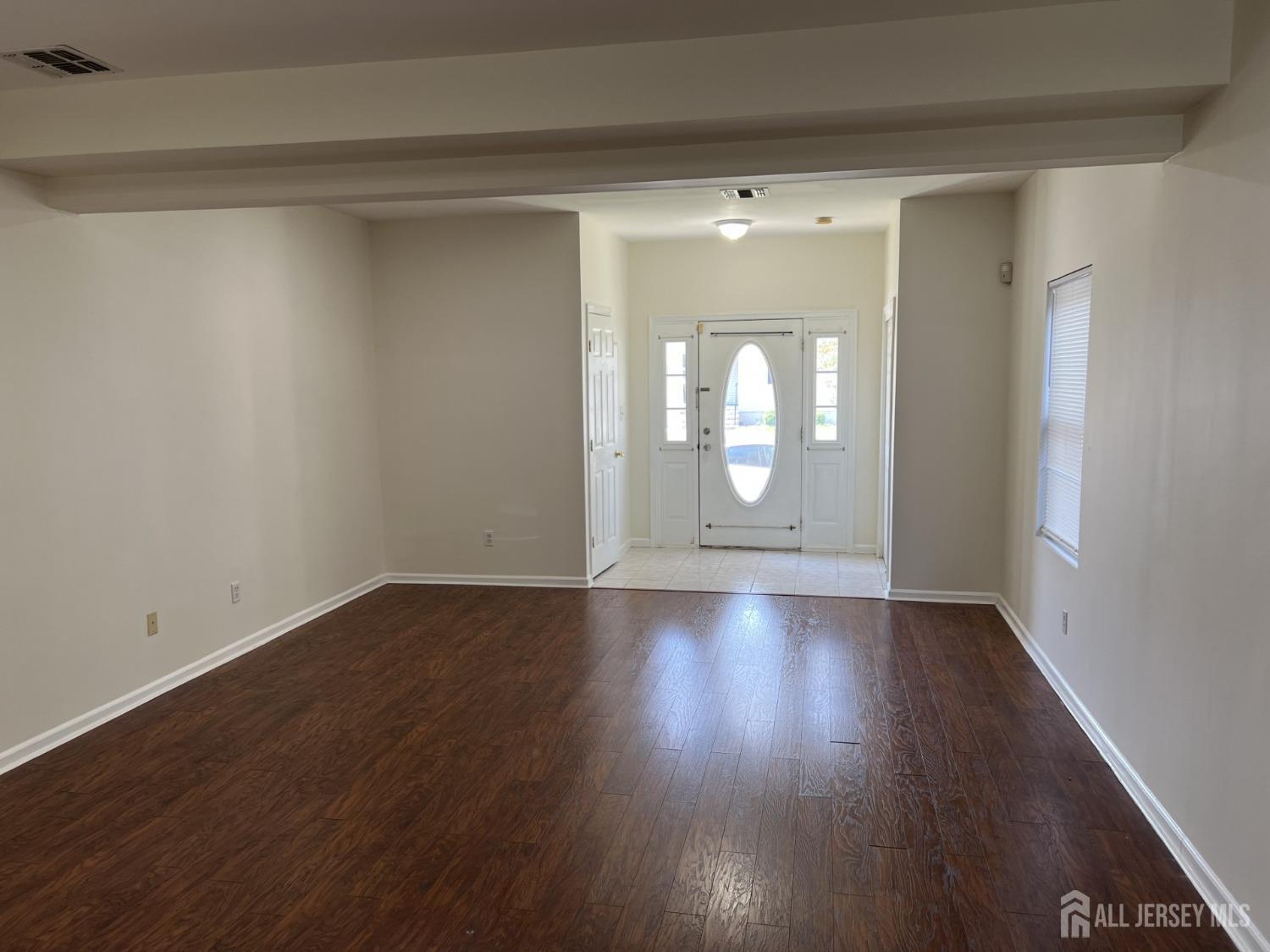 22 North Whittier Street, Unit B Carteret, NJ 07008 - Photo 15 of 27 a view of an empty room with wooden floor and a window