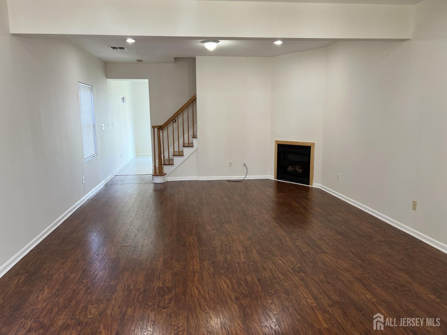 22 North Whittier Street, Unit B Carteret, NJ 07008 - Photo 16 of 27 a view of an empty room with wooden floor and a window