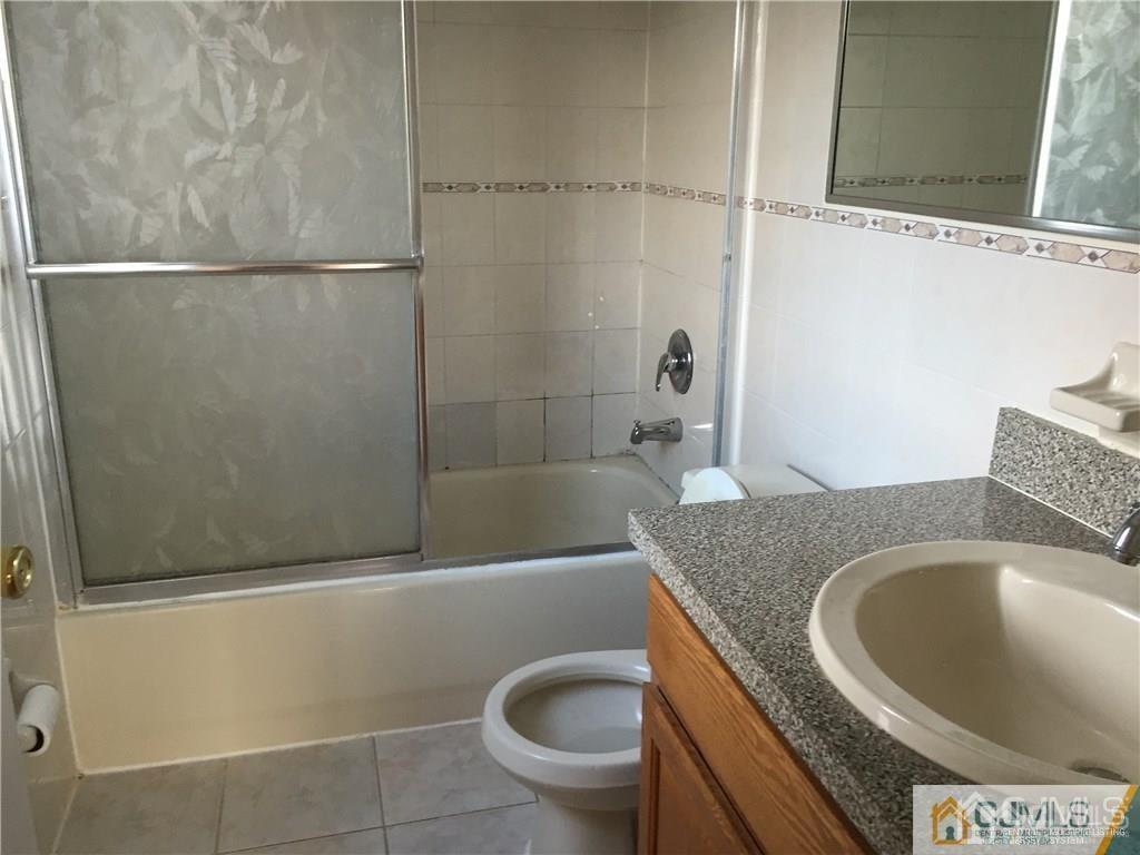 22 North Whittier Street, Unit B Carteret, NJ 07008 - Photo 2 of 27 a bathroom with a granite countertop bathtub and toilet