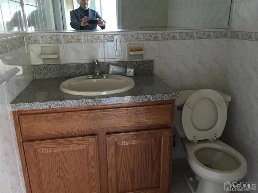 22 North Whittier Street, Unit B Carteret, NJ 07008 - Photo 3 of 27 a bathroom with a toilet sink and mirror