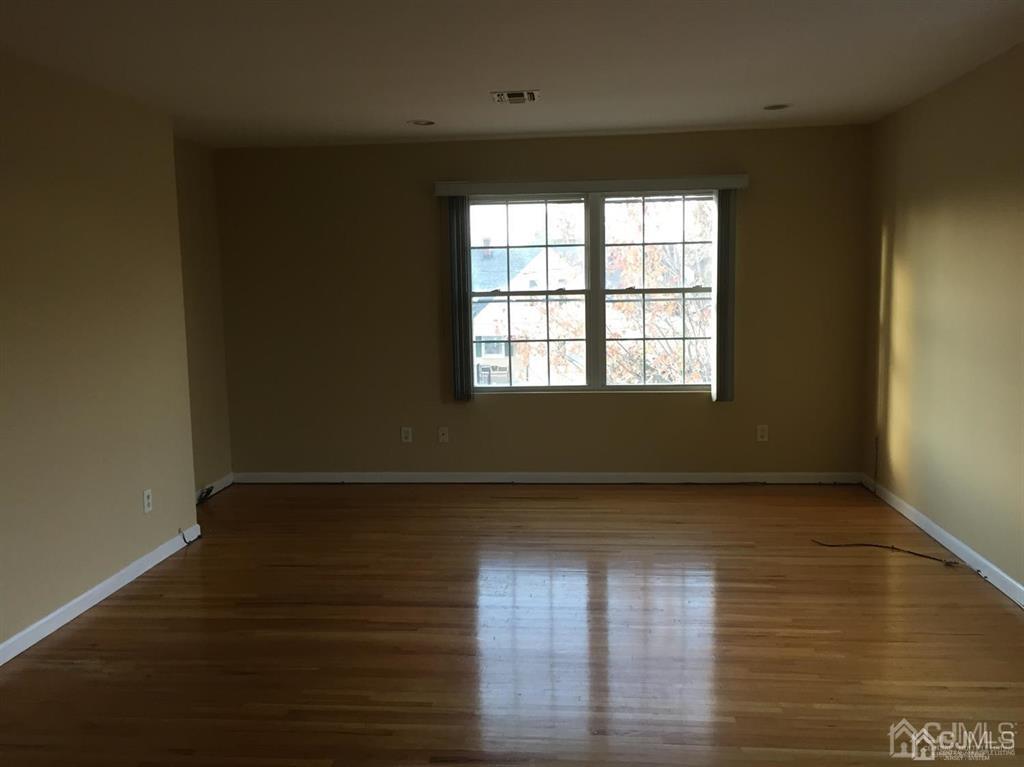 22 North Whittier Street, Unit B Carteret, NJ 07008 - Photo 5 of 27 a view of an empty room with wooden floor and a window