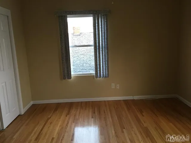 a view of a room with wooden floor and a window