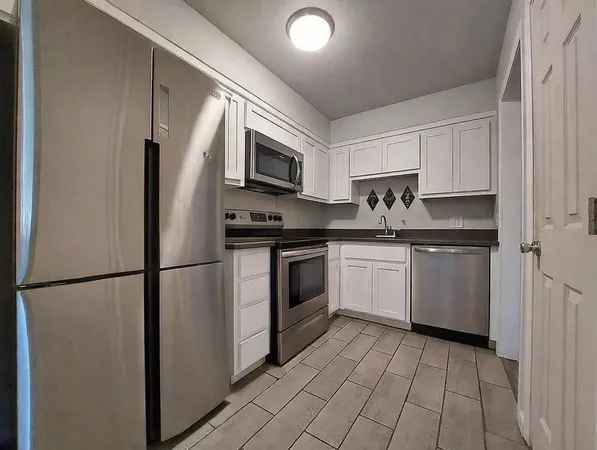 a kitchen with a sink appliances and cabinets