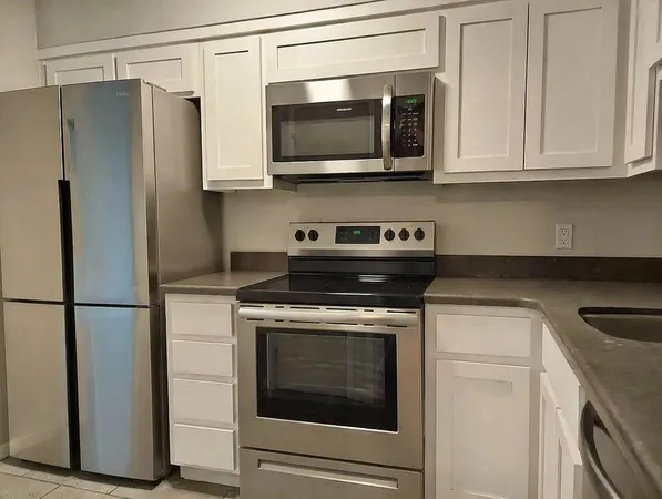 a kitchen with stainless steel appliances a stove microwave and refrigerator