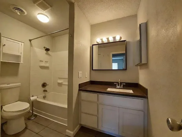 a bathroom with a toilet a sink a mirror and a bathtub