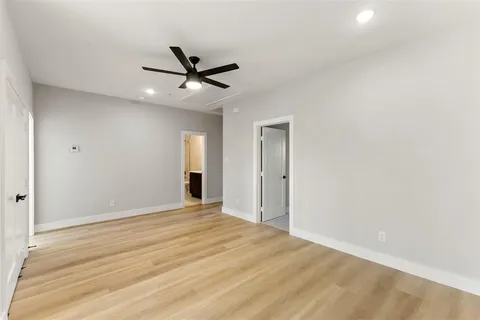 an empty room with windows and fan
