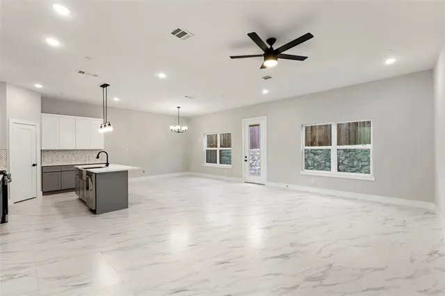 a large kitchen with a window and a ceiling fan