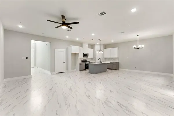 a kitchen with stainless steel appliances a sink a stove a refrigerator and cabinets