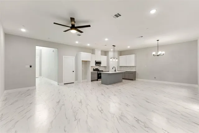 a kitchen with stainless steel appliances a sink a stove a refrigerator and cabinets