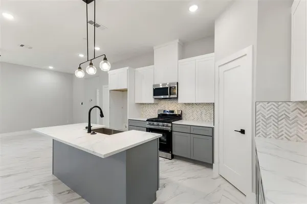 a kitchen with a sink a counter space appliances and cabinets