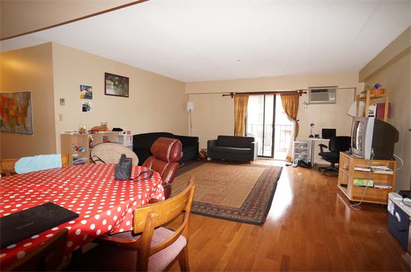 125 Pleasant Street, Unit 401 Brookline, MA 02446 - Photo 2 of 14 a bedroom with a bed and wooden floor