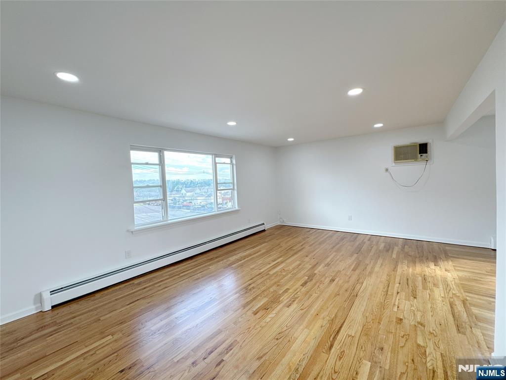 141 Westervelt Place, Unit 2 Lodi, NJ 07644 - Photo 2 of 10 an empty room with wooden floor and windows
