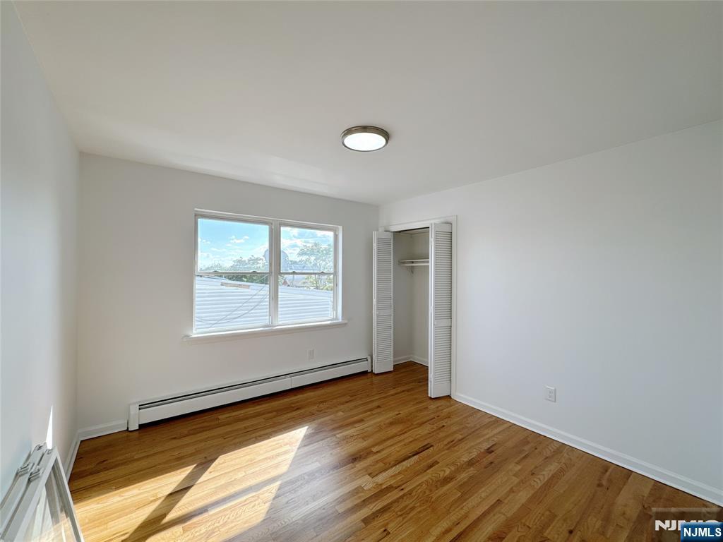 141 Westervelt Place, Unit 2 Lodi, NJ 07644 - Photo 3 of 10 an empty room with wooden floor and windows