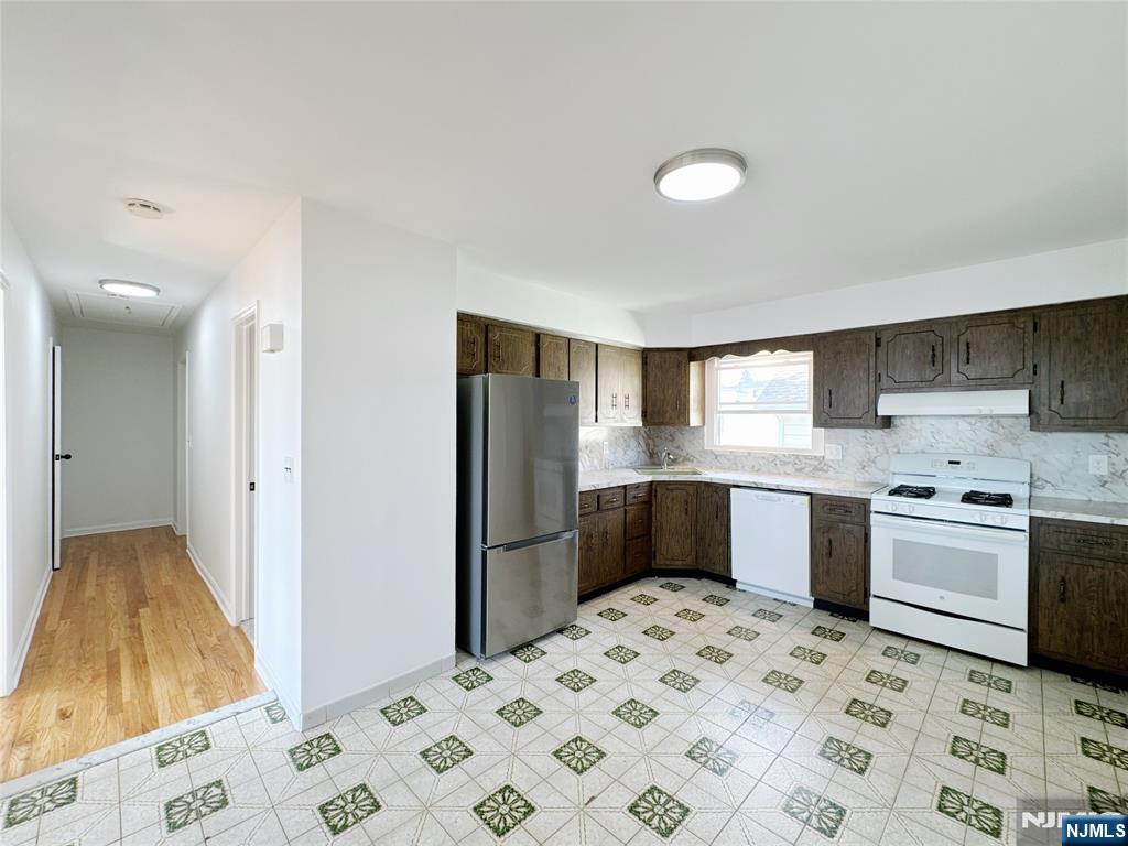 141 Westervelt Place, Unit 2 Lodi, NJ 07644 - Photo 7 of 10 a kitchen with stainless steel appliances kitchen island granite countertop a sink stove and refrigerator