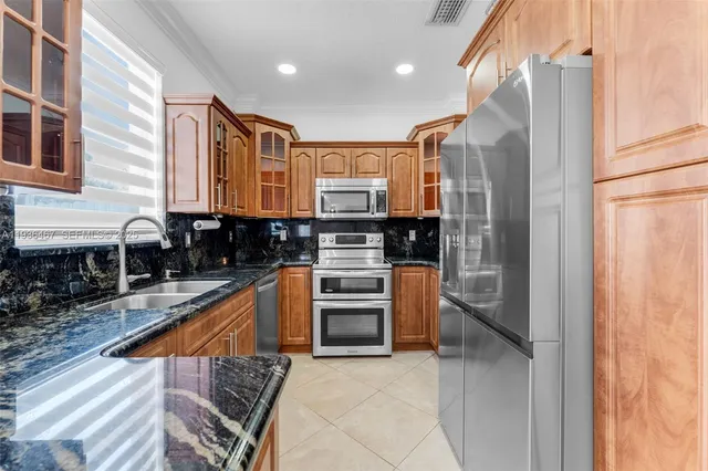 a view of a kitchen with furniture and stainless steel appliances
