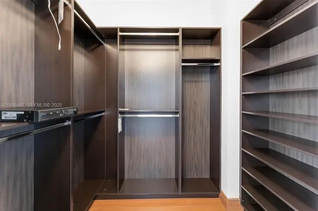 a view of walk in closet with empty racks