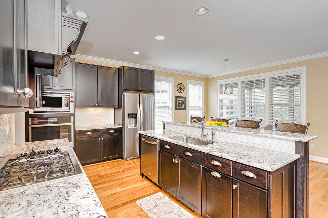 304 Redhill Road Holly Springs, NC 27540 - Photo 5 of 30 Gas stove, designer cabinets, NEW smart oven, granite countertops and plenty of room to entertain around the island. Kitchen