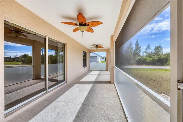 a view of empty room with wooden floor and kitchen