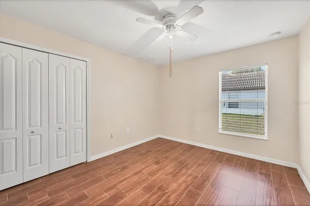 a view of a white house with a large yard and large trees