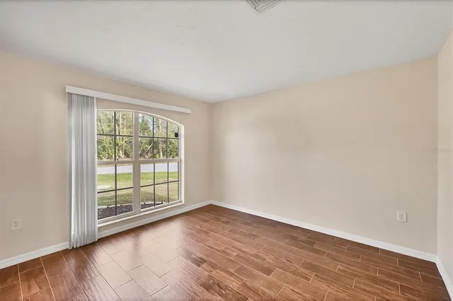 a view of a lake with a yard and large trees