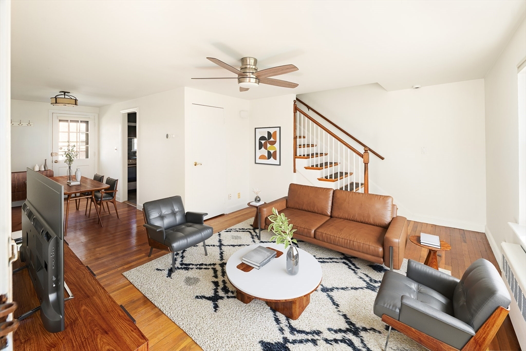 a living room with furniture and wooden floor