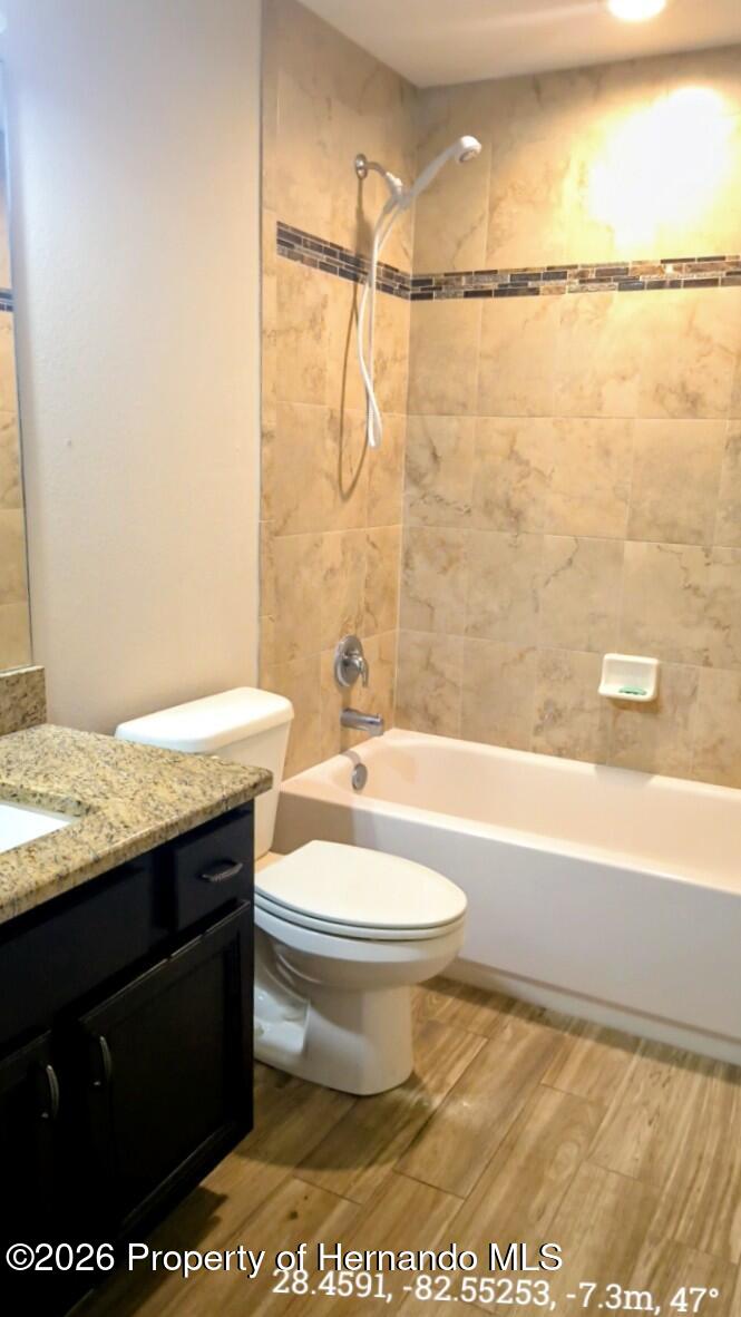 10244 Heathcliff Street Spring Hill, FL 34608 - Photo 23 of 30 a bathroom with a granite countertop sink toilet and shower