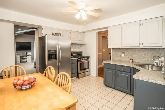 a kitchen with stainless steel appliances granite countertop a sink a stove and refrigerator