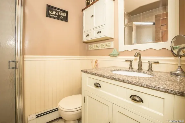 a bathroom with a granite countertop sink and a toilet