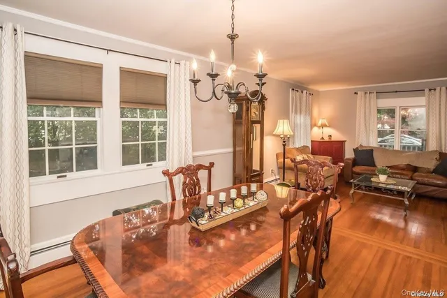 a view of a dining room with furniture a chandelier and large windows