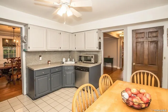 a kitchen with stainless steel appliances granite countertop a stove top oven a sink a dining table and chairs with wooden floor