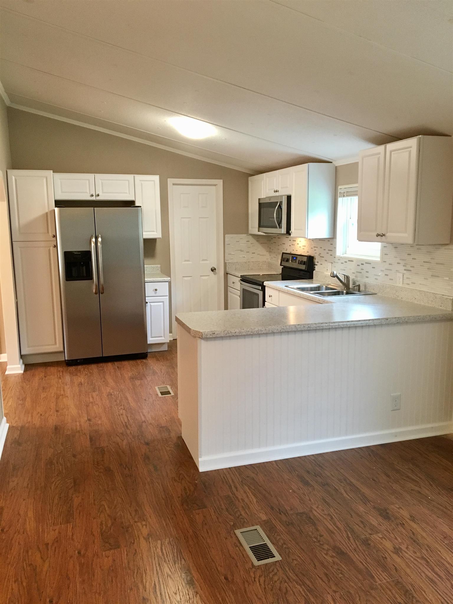 4302 Woodrow Wilson Road Springfield, TN 37172 - Photo 9 of 28 a kitchen with stainless steel appliances granite countertop a sink a stove top oven and wooden floors