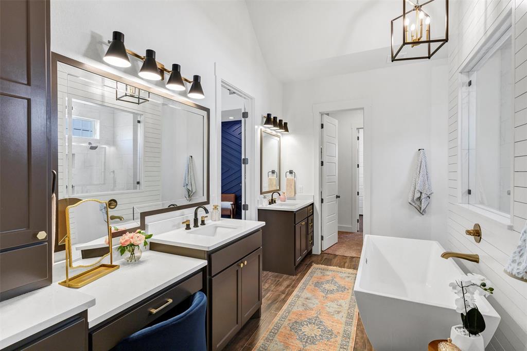 2105 Rattler Way Tolar, TX 76476 - Photo 22 of 30 a bathroom with double vanity sinks a mirror and a bathtub