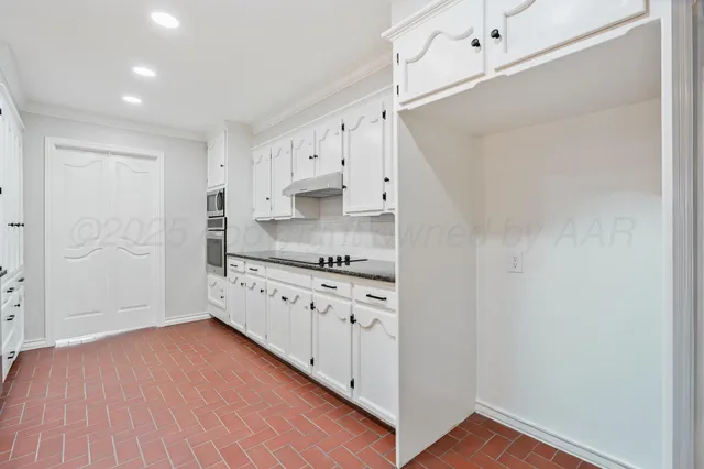 a kitchen with granite countertop white cabinets and white appliances
