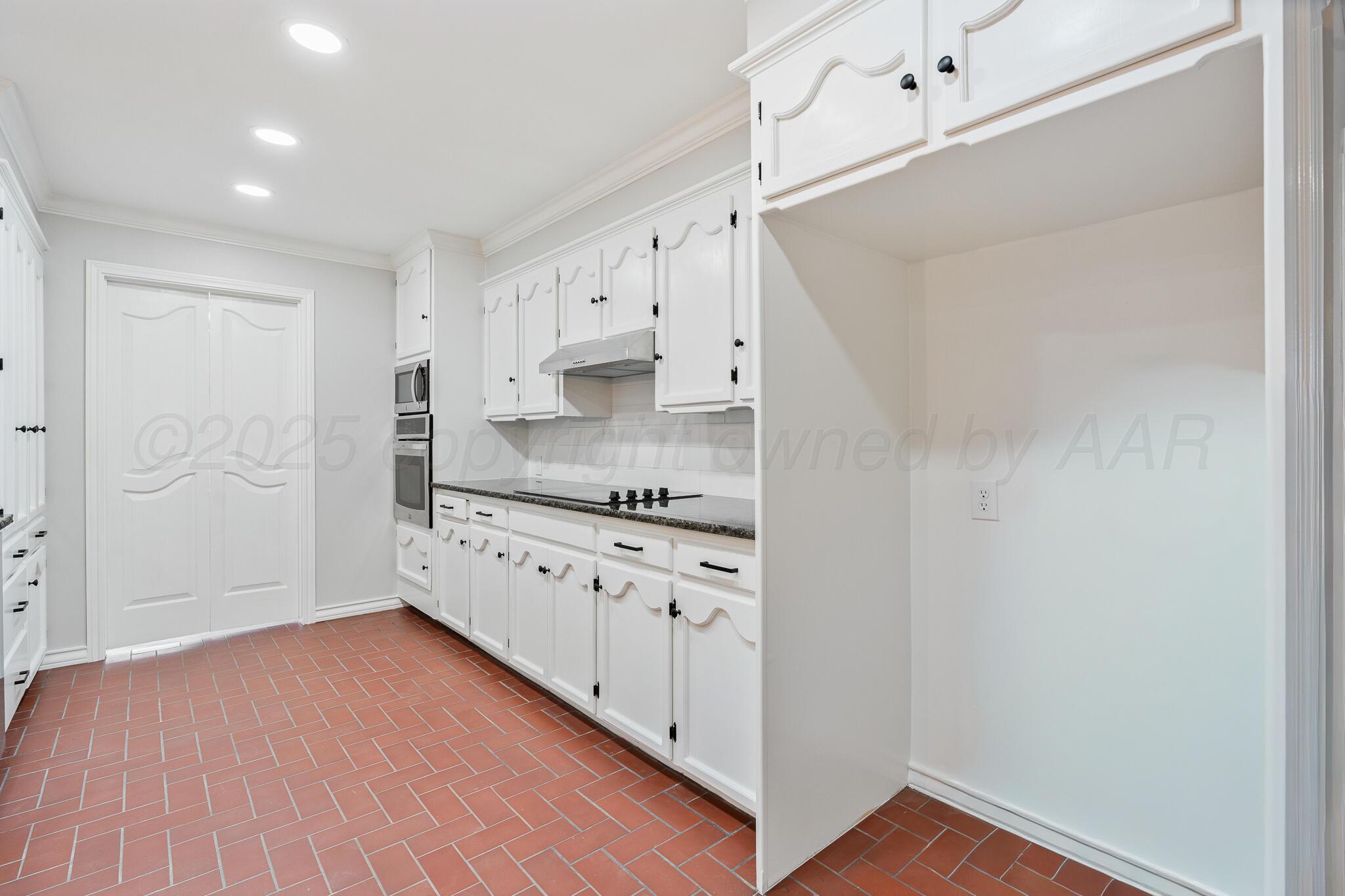 207 Yucca Terrace Plainview, TX 79072 - Photo 12 of 50 a kitchen with granite countertop white cabinets and white appliances