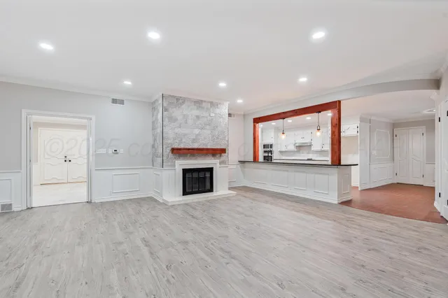 a view of empty room with wooden floor and fireplace