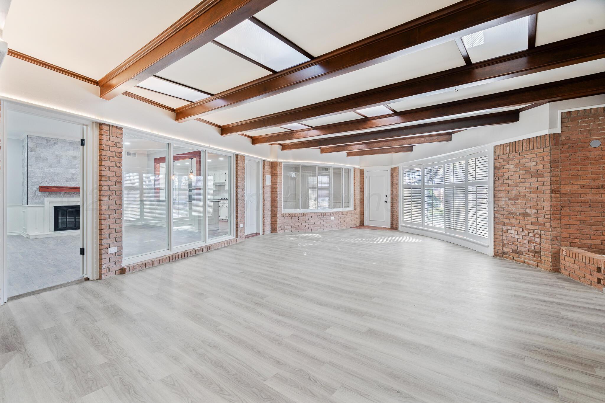 207 Yucca Terrace Plainview, TX 79072 - Photo 17 of 50 a view of an empty room with wooden floor and a window